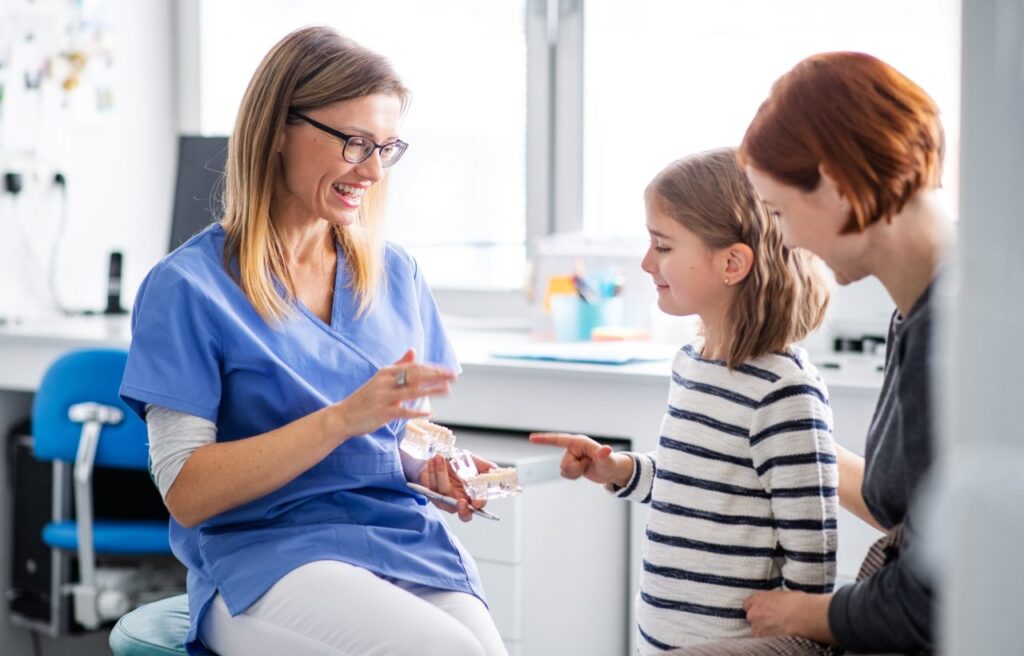a small girl mother and dentist in surgery dental checkup